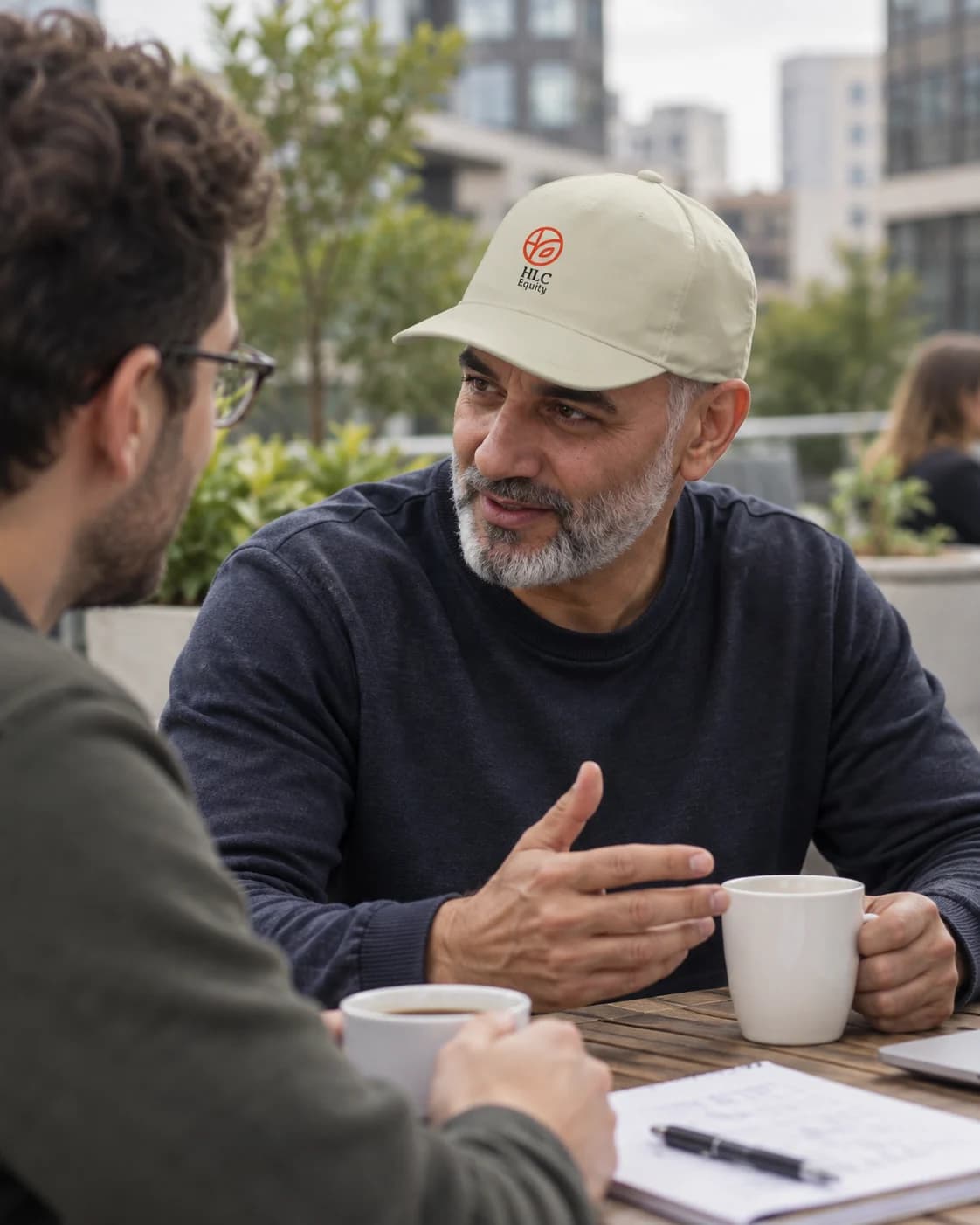 A colleague wearing an HLC Equity cap during a casual coffee break.