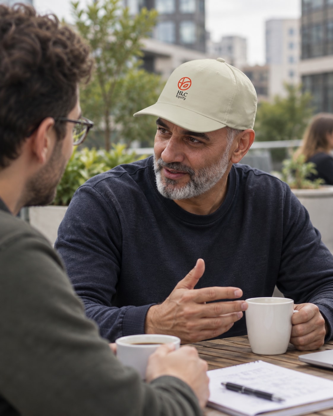 A colleague wearing an HLC Equity cap during a casual coffee break.