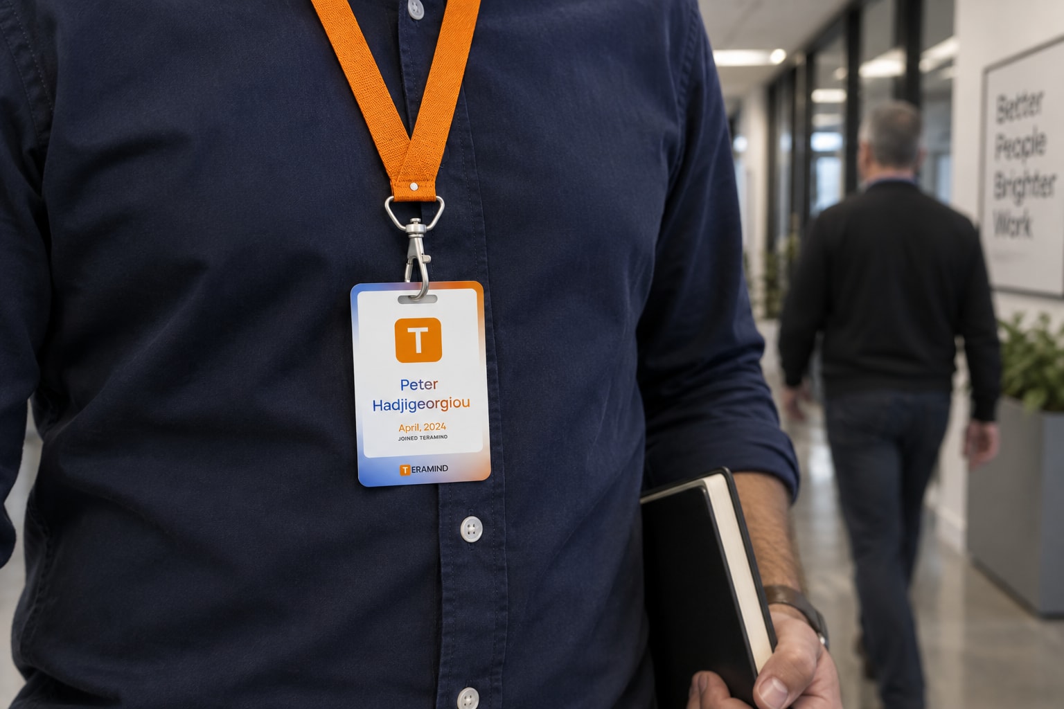 A Teramind badge worn in an everyday company office.