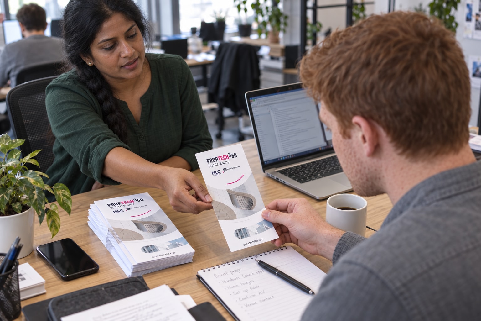 Two coworkers with distinct faces exchanging a PropTech360 printed handout.