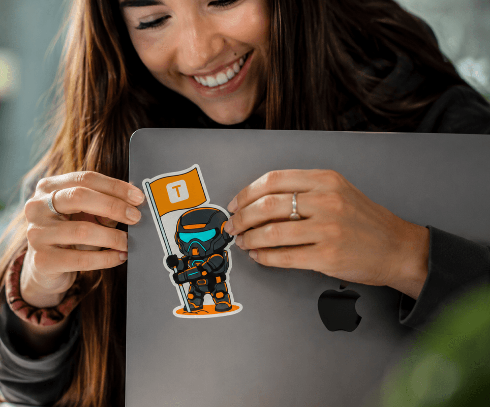 Applying a Timmy flag sticker to a laptop lid.